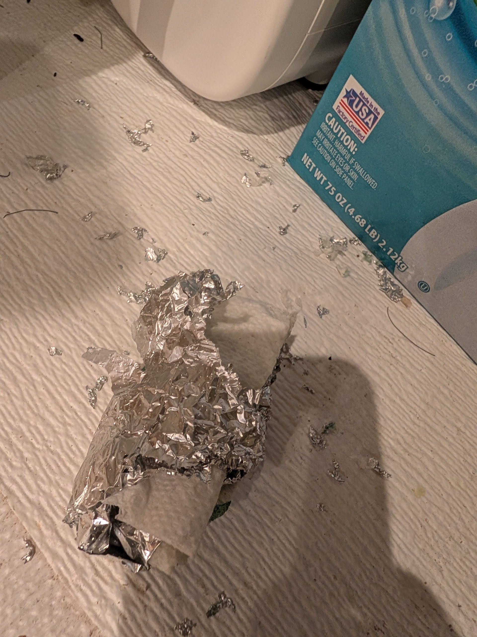 The kitchen cabinet aftermath - shredded paper and aluminum foil